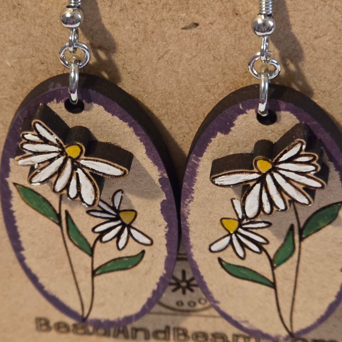 Floral earrings on a cardboard background with 'Beadsandboard' branding.