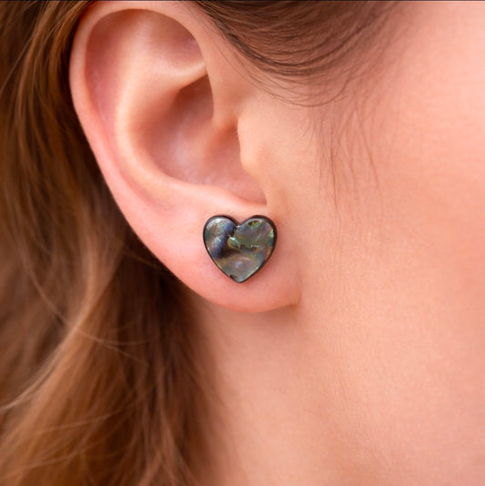 Heart-shaped earrings worn by a person with brown hair.