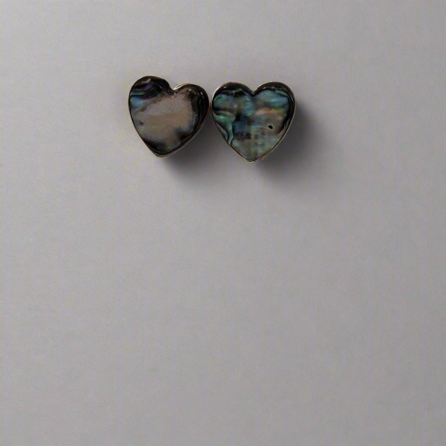 Heart-shaped earrings with a multicolored pattern on a light gray background