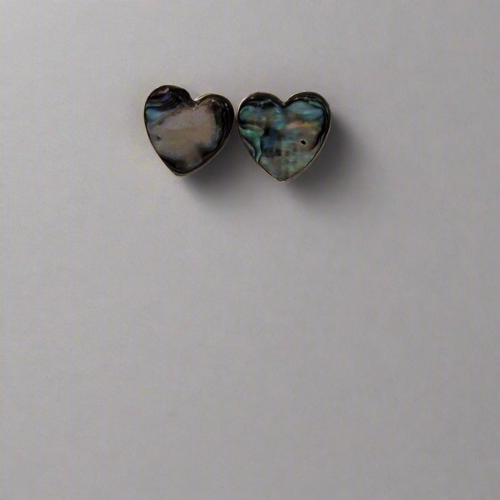 Heart-shaped earrings with a multicolored pattern on a light gray background