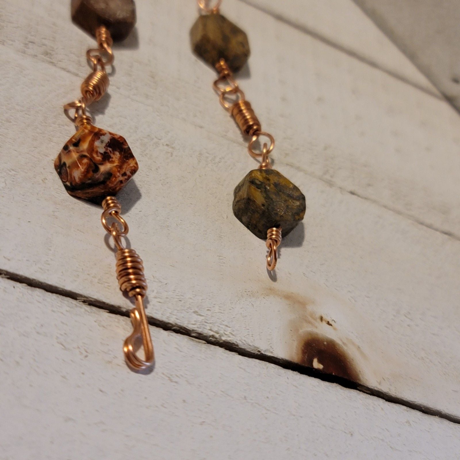 Bracelet with brown beads and gold wire on a wooden surface