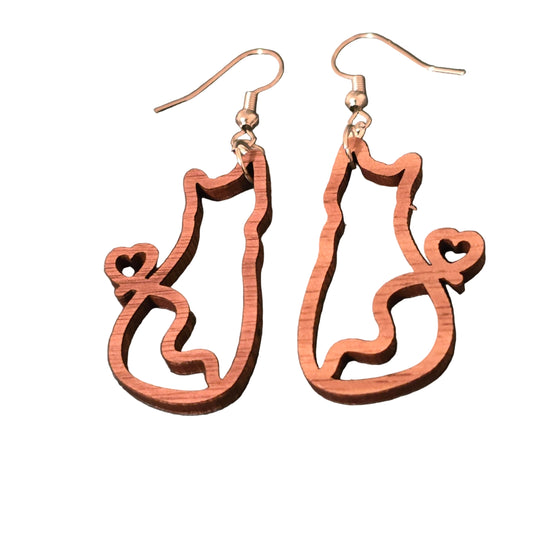Wooden cat-shaped earrings on a dark surface
