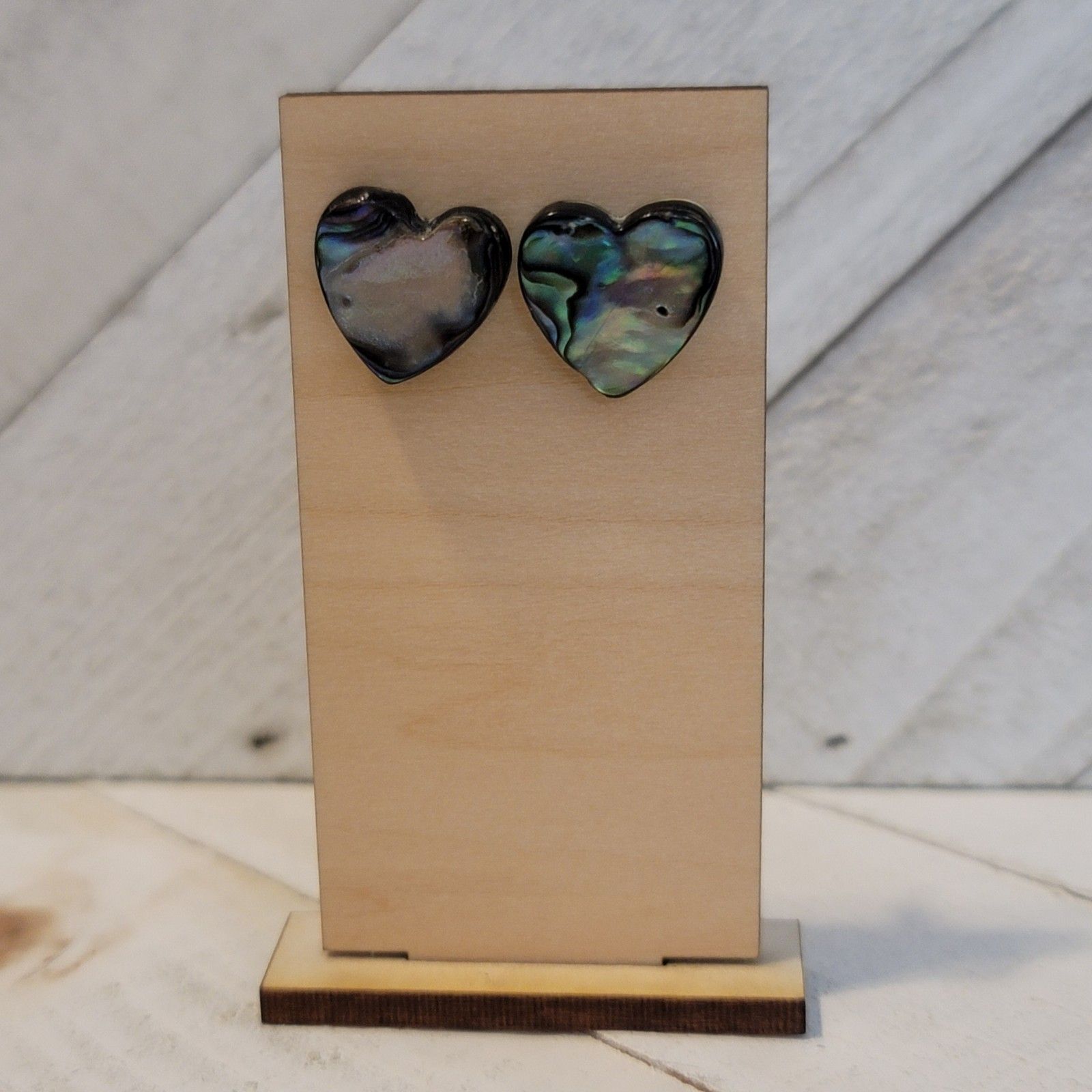 Heart-shaped earrings on a wooden stand with a light background