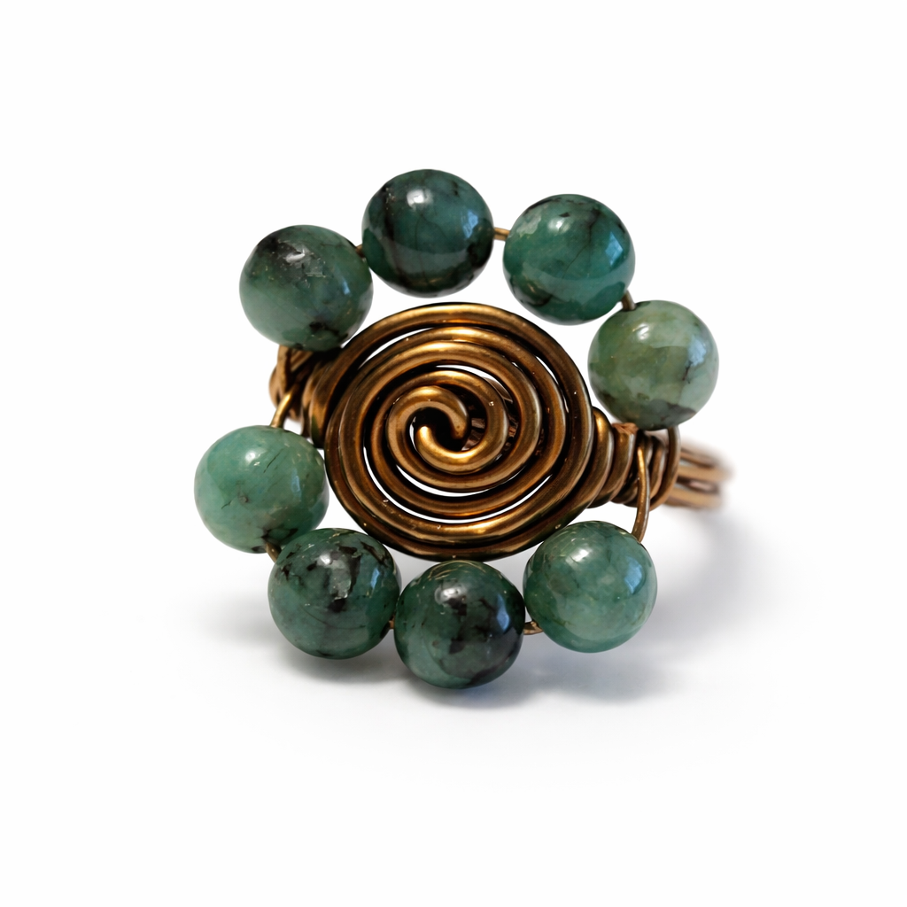 Ring with green beads and a bronze spiral design on a white background