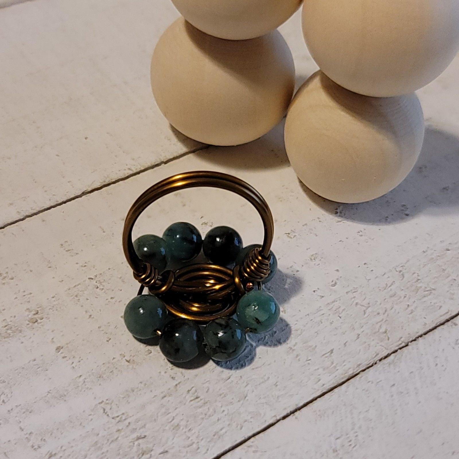 Small decorative basket with green beads on a light stone surface