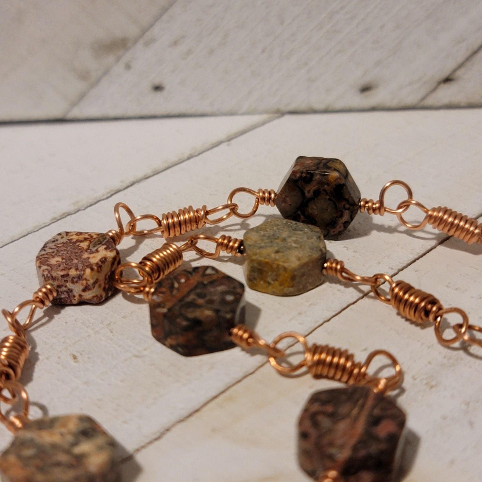 Brass bracelet with stone beads on a wooden surface