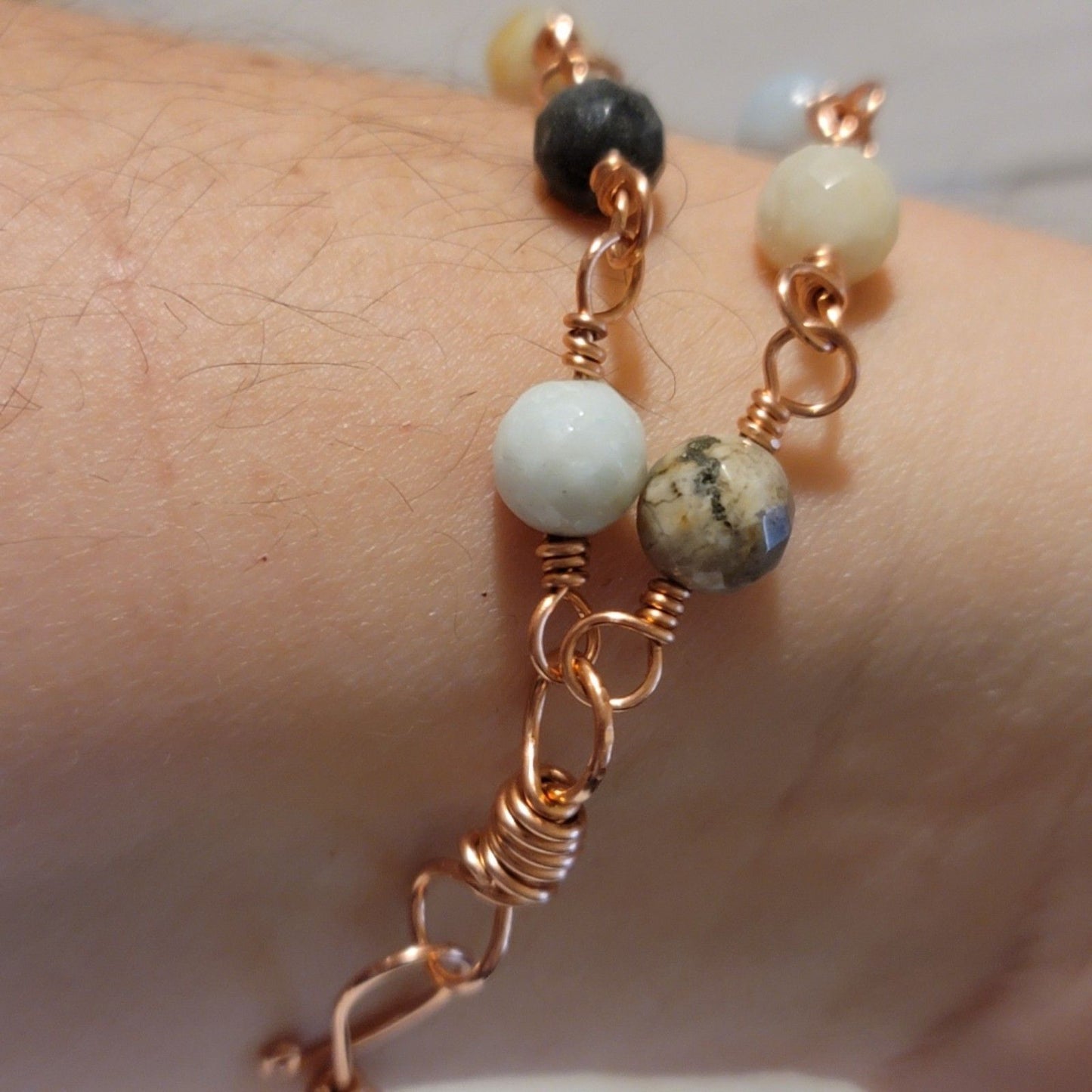 Bracelet with beads and rose gold chain on a wrist