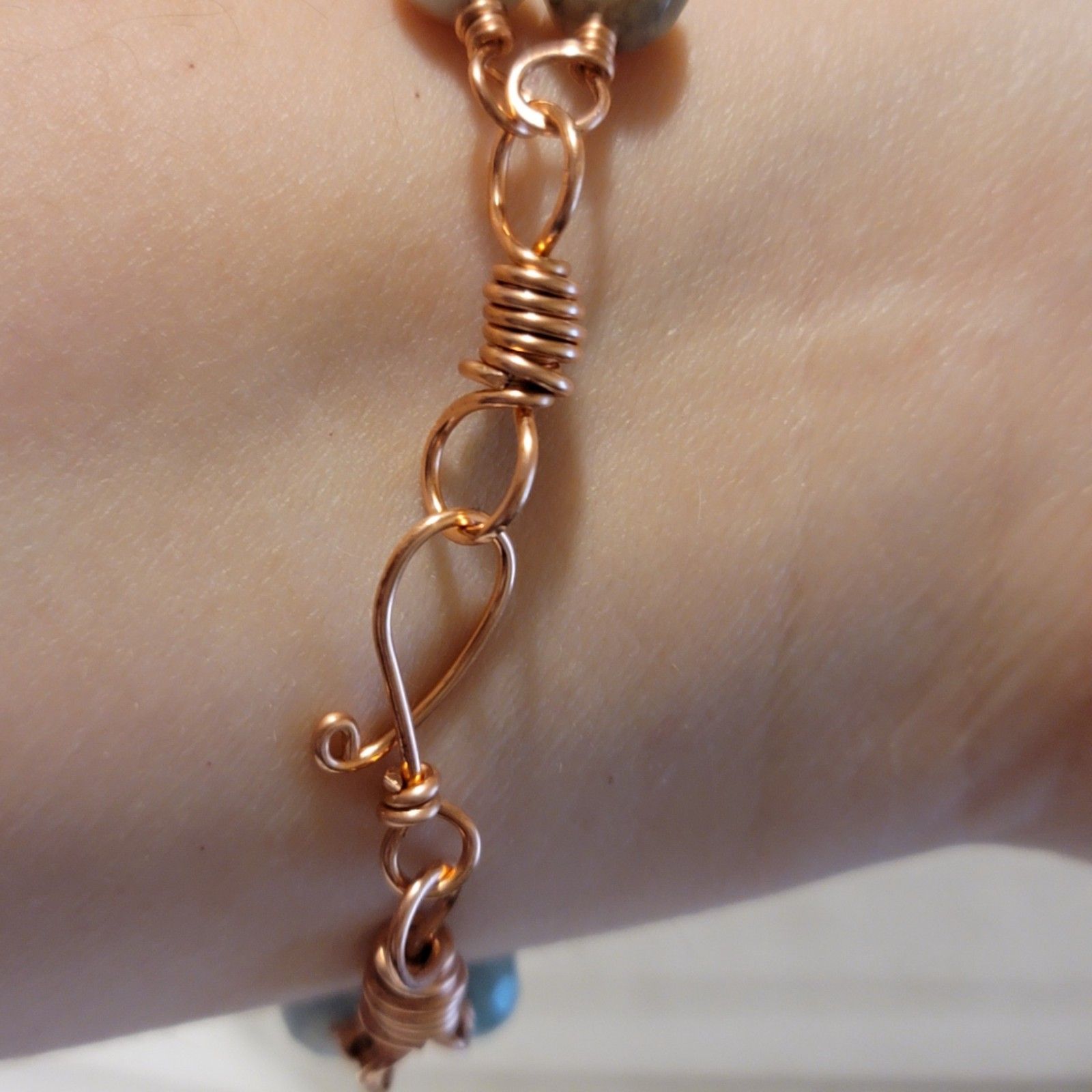 Close-up of a copper bracelet on a wrist with a blurred background