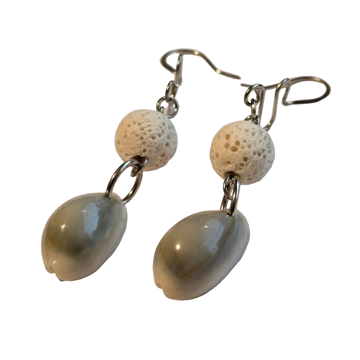 Pair of earrings with shell-like beads on a light background