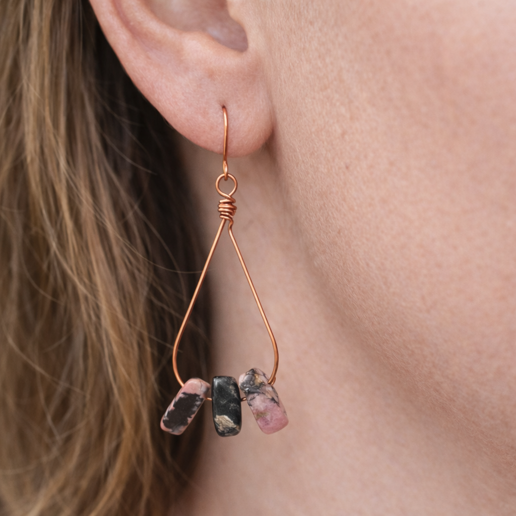 Earring with three dangling stones worn by a person