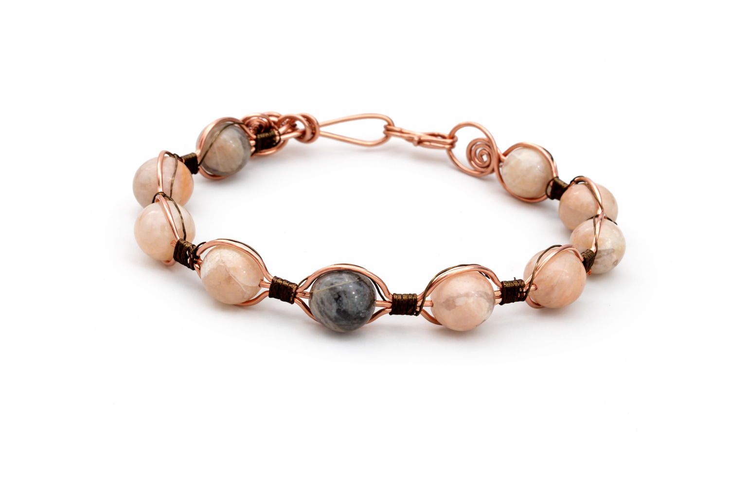 Bracelet with rose gold and pearl-like beads on a white background