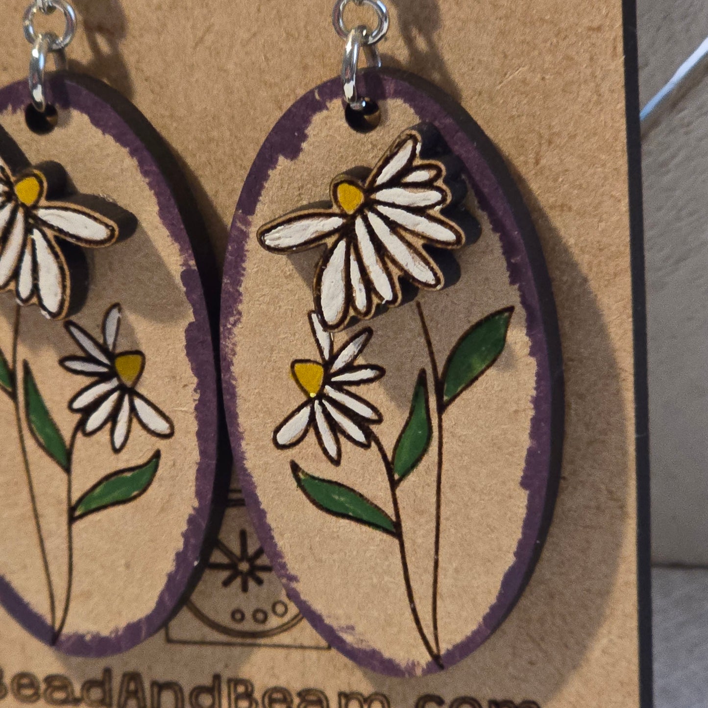 Floral earrings with daisy design on a textured surface