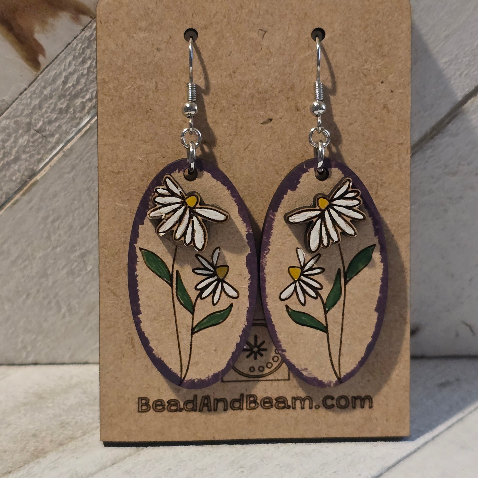 Floral earrings on a branded cardboard backing