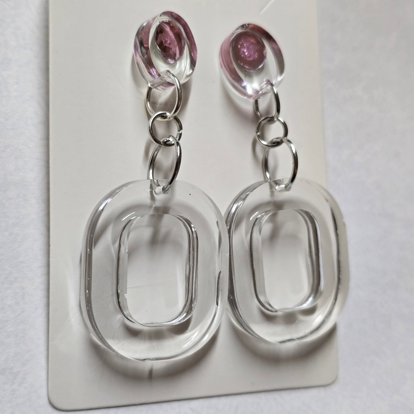 Two clear plastic keychains with pink beads on a white background