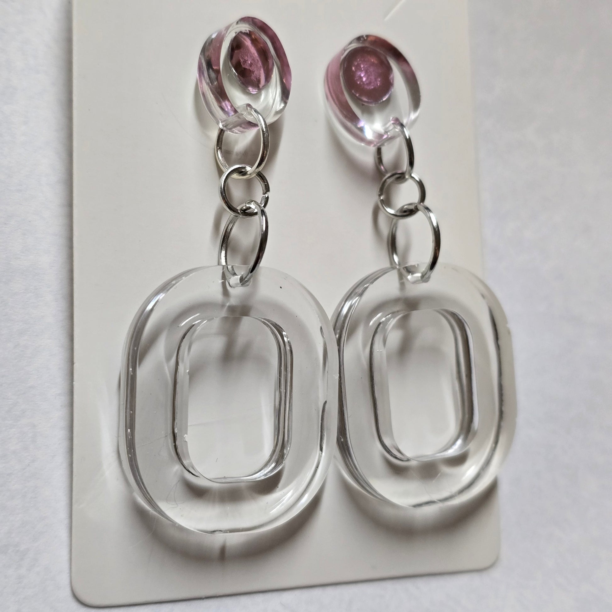 Two clear plastic keychains with pink beads on a white background